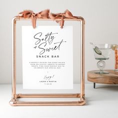 a sign that says salty and sweet next to a glass filled with drinks on a table