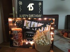 a birthday card with popcorn and candles on a table in front of a sign that says happy birthday