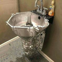 a metal sink sitting in the corner of a bathroom