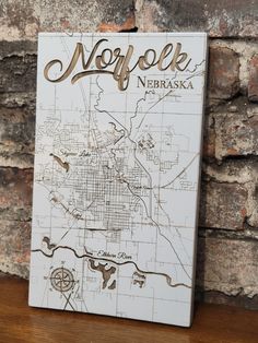 a wooden sign with the name and map of norfolk, new york on it's side