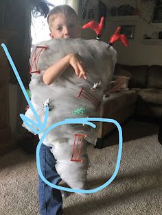 a young boy is holding a large bag with birds on it