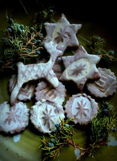 some cookies with icing and sprigs on a plate