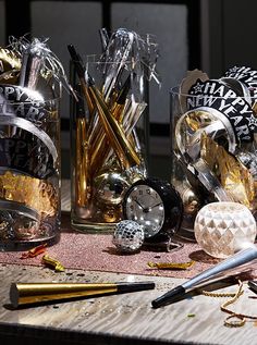 various items are sitting on a table with gold and silver decorations in glass vases