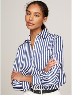 Tommy Hilfiger women's shirt. A bold stripe design makes this versatile, oversized, stretch-cotton shirt an easy choice for the office and the hours beyond.  Material: 97% Better Cotton Initiative, 3% Elastane. Relaxed Fit Contrast Stripe Workwear Tops, Relaxed Fit Contrast Stripes Top For Work, Relaxed Fit Contrast Stripe Tops For Work, White Tops With Signature Stripes For Workwear, Relaxed Fit Tops With Contrast Stripes For Workwear, Relaxed Fit Top With Striped Collar For Business Casual, Spring Workwear Top With Signature Stripes, Classic Relaxed Fit Tommy Hilfiger Shirt, Classic Relaxed Fit Blouse With Vertical Stripes