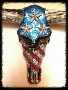 a cow skull with stars and stripes on it's head hanging from a wall