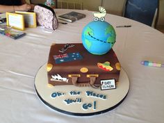 a cake that is shaped like a suitcase and has a small globe on top of it