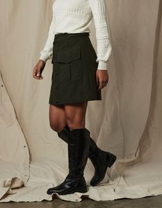 Classic military-inspired detailing and fabric. Made from a boiled wool blend with a brushed face for warmth and lined with lightweight polyester for comfort. The true-to-size, hi-rise, A-line skirt falls at mini length for a modern silhouette. Features a full button front, front patch pockets with box pleats and hidden snaps, a set-on waistband with button tabs, and front and back princess seams. Henley Sweater, Boiled Wool, Princess Seams, Fall Skirts, Military Inspired, Box Pleats, Overall Dress, Green Skirt, Fall Shopping