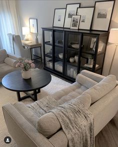 a living room filled with furniture and pictures on the wall