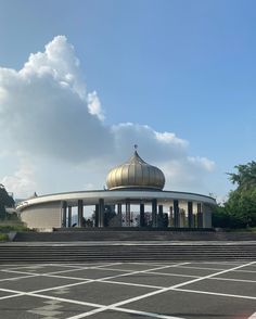 an empty parking lot in front of a building with a domed structure on the top