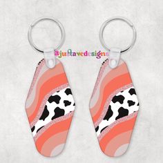 two cow print keychains are shown with the word, you have to say it is