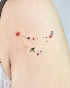 the back of a woman's shoulder with planets and stars on it