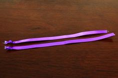 two purple toothbrushes sitting on top of a wooden table