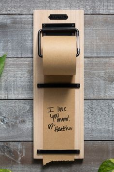 a toilet paper holder with a note attached to it