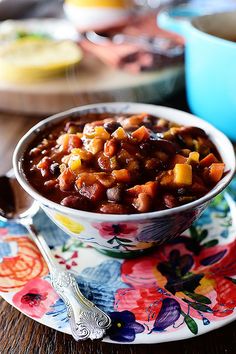 a bowl filled with chili on top of a colorful plate