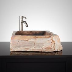 a stone sink with a faucet on top of it