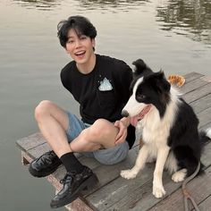 a man sitting on a dock with his dog next to him and smiling at the camera