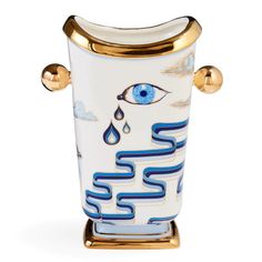 a white and gold vase with blue eyes on it