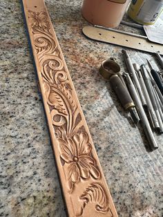 some tools are laying out on the counter next to it's carving board and paint