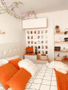 an orange and white bedroom with pictures on the wall