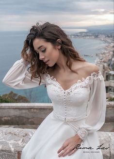 a woman in a white dress is posing for the camera with her hands on her head