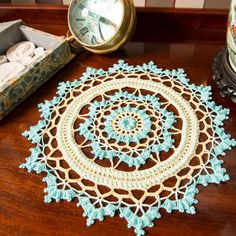 a crocheted doily sits on a table next to a clock and other items