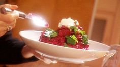 a person lighting a lighter on a bowl of food