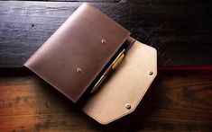 a brown leather wallet with a pen in it