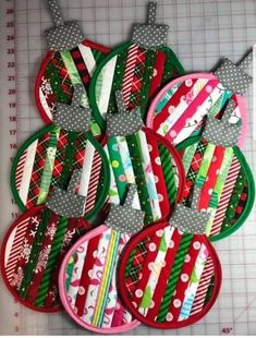 some christmas ornaments are sitting on a cutting board with tape and scissors next to them