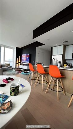 a living room filled with furniture and a flat screen tv mounted to the side of a wall