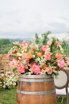 a wooden barrel filled with lots of flowers