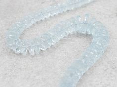 a close up of a glass bead necklace on a white surface with no beads