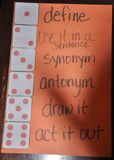 an orange sign with white dices on it that says, define use it in a sentence syphonmy antony draw it act it out