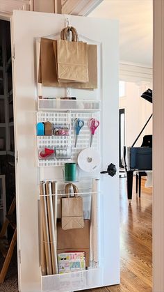 an open closet with paper, scissors and bags on the shelves in front of it