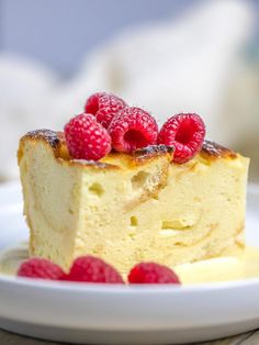 a piece of cake on a plate with raspberries