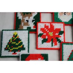 cross - stitch christmas coasters are arranged on a table