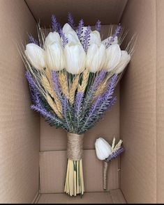 a bouquet of white and purple flowers in a cardboard box