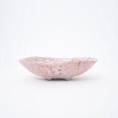 a pink and white bowl sitting on top of a table