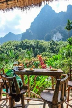 an outdoor table and chairs with mountains in the background