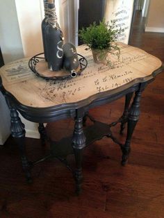 an old table with some plants on top and writing all over the surface in front of it