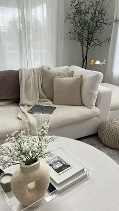 a living room filled with furniture and a white coffee table in front of a window