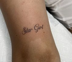 a woman's arm with the word star girl tattooed on her left side, in cursive font