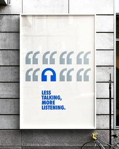 a poster on the side of a building that says less talking, more listening and an image of a bike leaning against it