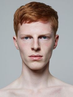 a man with red hair and blue eyes is looking at the camera while wearing no shirt