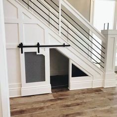 a dog house under the stairs with its door open