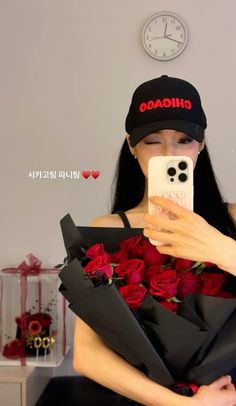 a woman taking a selfie with her cell phone while holding a bouquet of roses