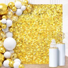 gold and white balloons are in front of a backdrop with golden sequins on it