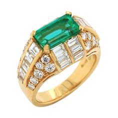 An emerald and diamond ring in yellow gold by Bulgari, ca. 1970s. The Trombino is a very popular and iconic ring model by Bulgari. The ring has a very smart and luxurious design, emphasising the centre gemstone, with the diamonds set in a manner that accentuates the emerald really well. The centre stone is a Columbian emerald with a vivid green colour, some non eye-visible natural growth inclusions and a stunning crystal, weighing approximately 2.39ct (inscribed on the ring). It is surrounded by Double Diamond Ring, Diamond Gold Ring, Ring Model, Emerald And Diamond Ring, Platinum Diamond Rings, Emerald Diamond Ring, Gold Cocktail Ring, Gold Rings Fashion, Rings Fashion