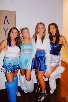 four girls dressed up in costumes posing for the camera