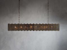 a chandelier hanging from the ceiling in a room with concrete walls and flooring