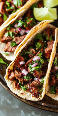 three tacos with meat, onions and cilantro on a plate